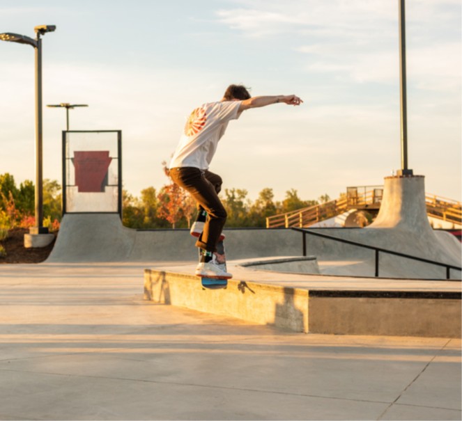 Skate boarder jumping in skate park