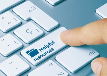 A finger hitting a button on a keyboard for "Helpful resources"